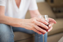 Detailed shot of hands holding a wine glass indoors, symbolizing relaxation and leisure.