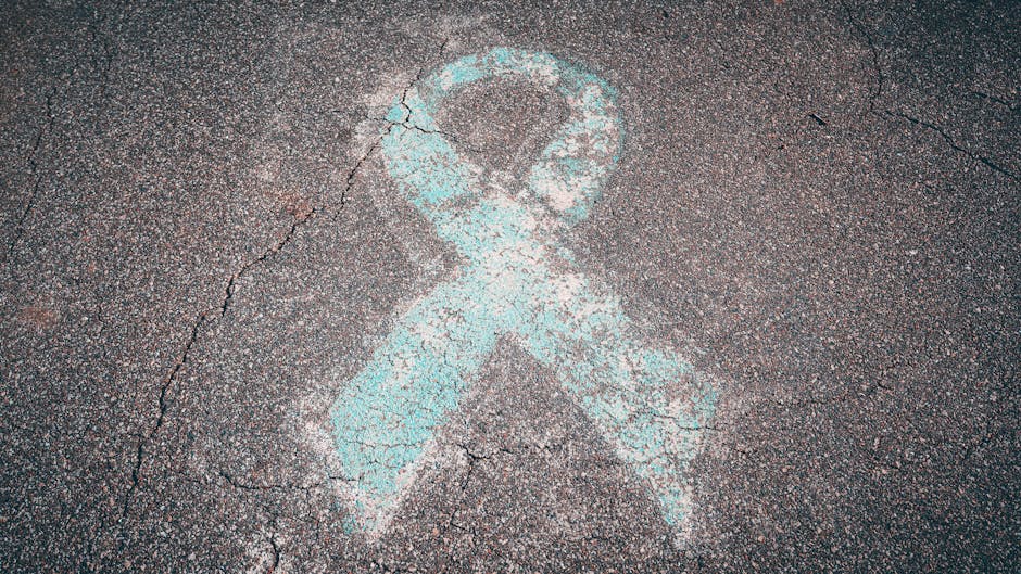 Blue awareness ribbon chalked on cracked pavement symbolizing support and awareness.
