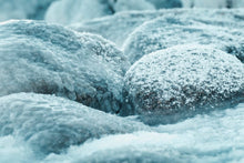 Close-up of snow-covered rocks in a serene winter setting.