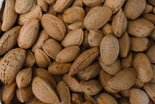 Detailed photograph of raw almonds with shells, highlighting natural texture and organic appeal.
