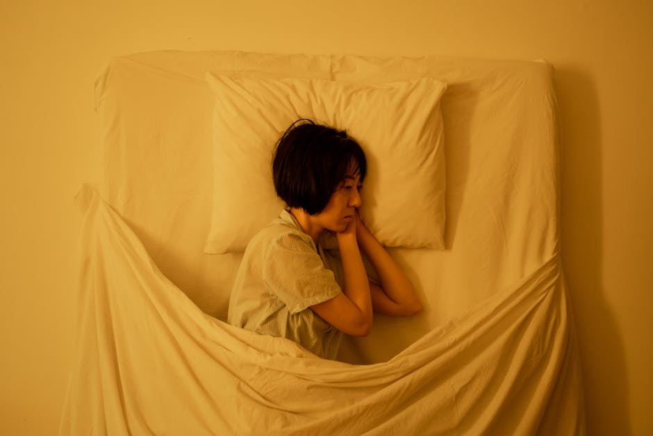 A woman lies in bed, reflecting deep emotions related to mental health issues.