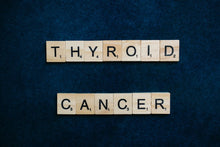 Scrabble tiles spelling 'Thyroid Cancer' on a dark blue background representing awareness.