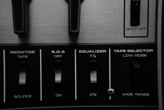 Black and white close-up of an audio control panel featuring an equalizer and switches.